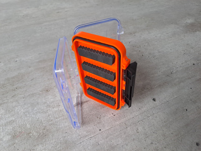 Orange transparente Fliegenbox aus Kunstoff doppelseitig mit schwarzen Schaumstoffeinlagen zur Aufnahme der Fliegen