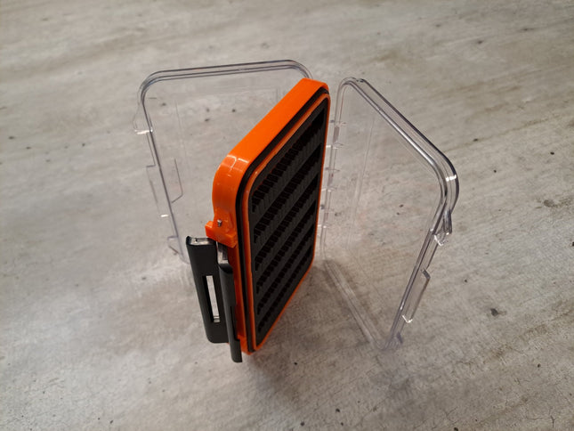 Orange transparente Fliegenbox aus Kunstoff doppelseitig mit schwarzen Schaumstoffeinlagen zur Aufnahme der Fliegen